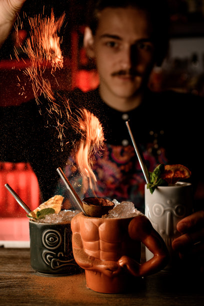 吧台上有三个形状各异的杯子，里面装着冰块，其中一个还生着火图片下载