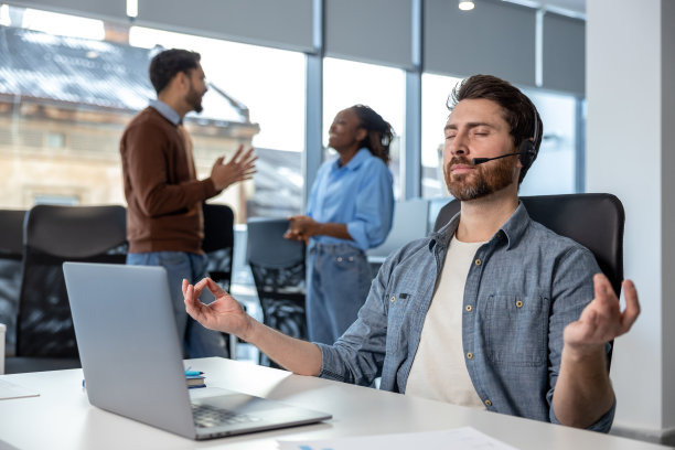 帅气的呼叫中心接线员在工作时练习瑜伽图片下载