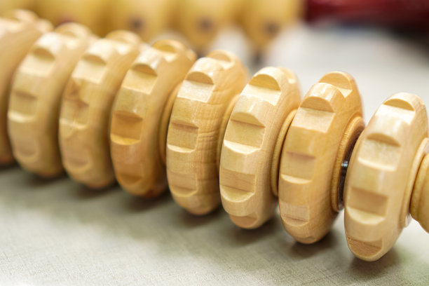 一个特别设计的按摩和伸展装置的特写，由硬木制成，可以轻松地在胳膊和腿上滚动。图片下载