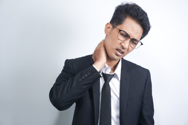 一个脖子疼的年轻人。头痛。压力大，不开心的年轻帅哥脖子疼得厉害图片下载