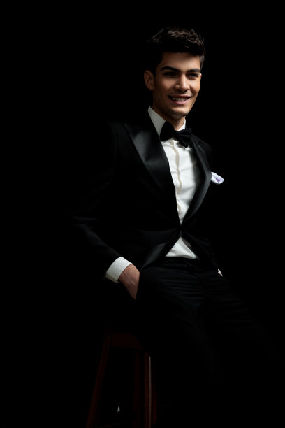 穿着黑色西装的新郎坐在座位上笑着图片下载