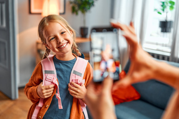 童年的照片。开心的女学生看着手机镜头，露出露齿的微笑图片下载