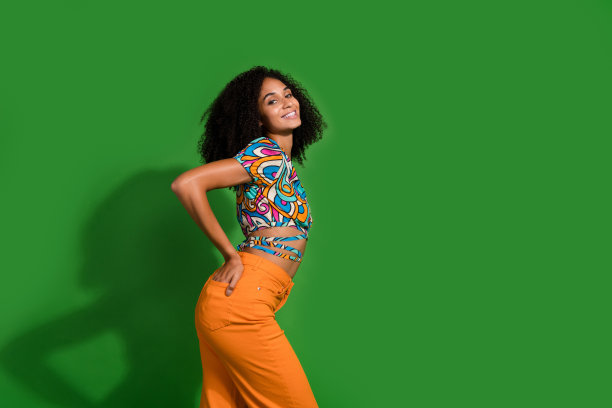 照片中，一位年轻漂亮的女士喜欢春天，她穿着时尚的浅色衣服，靠近绿色背景的copyspace图片下载