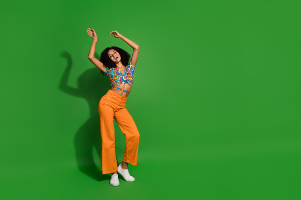 年轻别致的全身照片在时尚的复古衬衫，举起手臂，而舞蹈怀旧音乐孤立的绿色背景图片下载