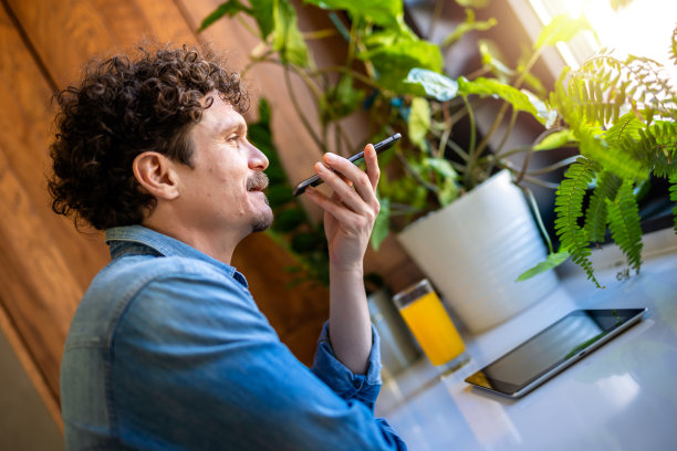 拉丁裔男子正在用手机发语音信息。图片下载