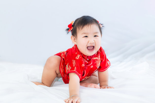 中国新年概念，可爱快乐的小女孩穿着中国服装坐在白色的客厅里。可爱的亚洲宝宝坐在白色的客厅里，中国新年的概念。图片下载