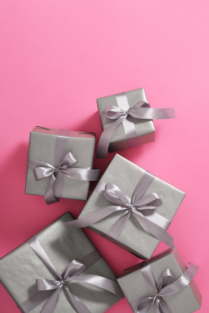 灰色礼品盒与银带粉红色的背景。垂直，留出文字空间。图片下载