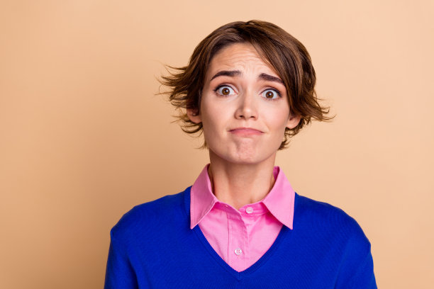 照片中郁郁寡欢的女士穿着蓝色毛衣准备哭泣，空白空间孤立的米色背景图片下载