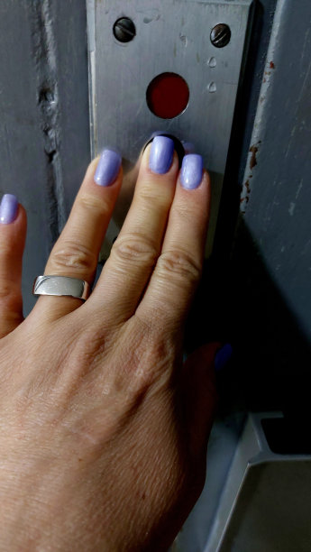 电梯里的女人用手按按钮。人的照片。图片下载