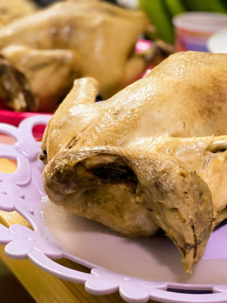 一张盘子的照片，盘子上有一只鸡，背景是一碗食物。图片下载