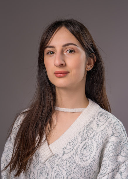 一个年轻女子的肖像，特写，在灰色背景上图片下载