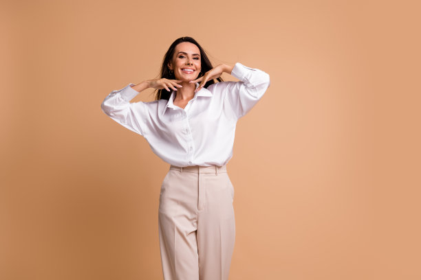 照片中可爱漂亮优雅的女士双手触摸脸舒适轻盈空空间孤立在米色背景图片下载