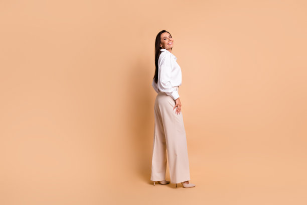 令人惊叹的正面女士的全身侧面照片摆出优雅的衣服，空白的空间孤立在米色背景上图片下载