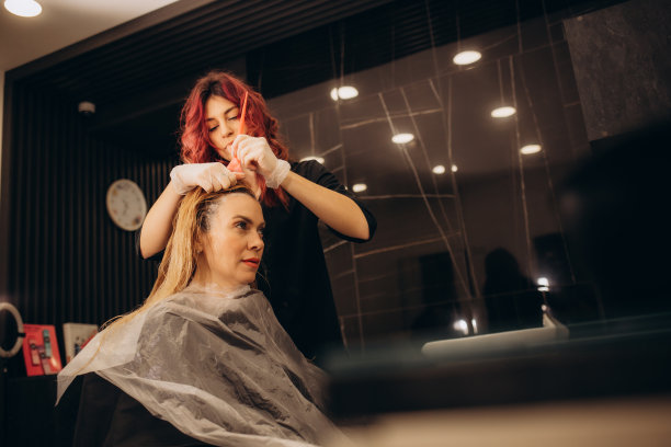年轻美女在现代美容院染发，专业发型师为女性洗发染色图片下载