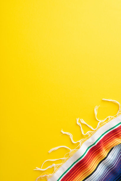 五月五日节活动写照。俯视图垂直照片捕捉聚会必备:明亮的条纹披风在阳光明媚的黄色背景，有空间的说明文字图片下载