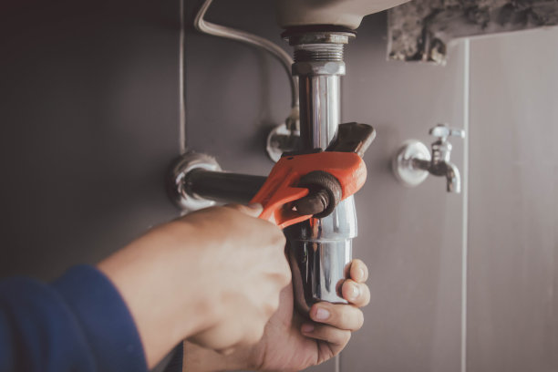 在浴室工作的水管工，管道维修服务，修理水管道泄漏，更换厨房水槽排水管图片下载