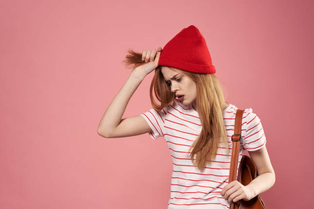 漂亮的女人在红色的帽子照片情感喜悦粉红色的背景图片下载