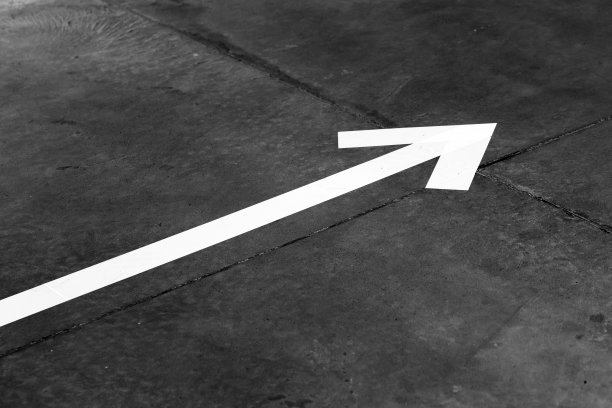 白色的箭头穿过深色的混凝土地板，抽象的照片图片下载