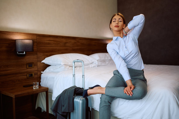 疲惫的女商人躺在酒店房间的床上。图片下载