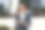 一个穿着夹克、面带微笑的男人在户外拿着咖啡和手机的照片。图片下载