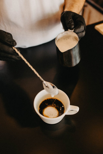 咖啡师用牛奶准备咖啡的特写照片图片下载