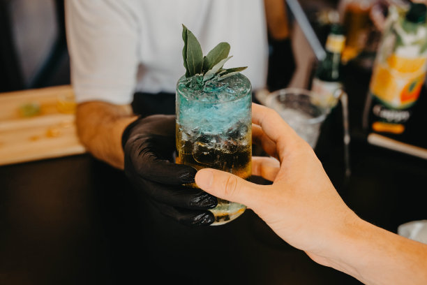 在餐馆里，一杯冷饮鸡尾酒被端给顾客的特写照片图片下载