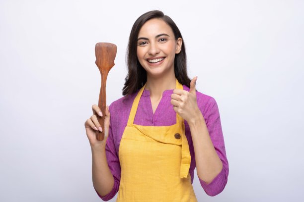 年轻女厨师的肖像穿着黄色围裙孤立白色背景股票照片图片下载