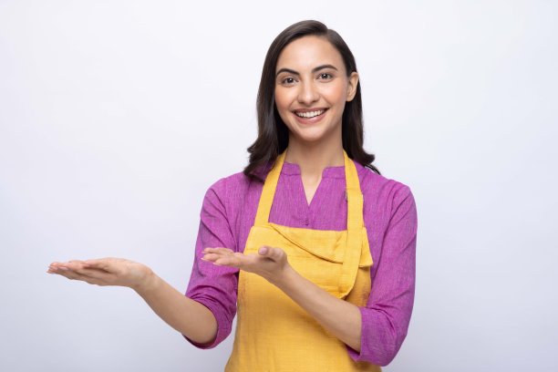 年轻女厨师的肖像穿着黄色围裙孤立白色背景股票照片图片下载