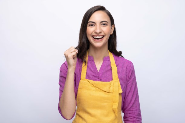 年轻女厨师的肖像穿着黄色围裙孤立白色背景股票照片图片下载