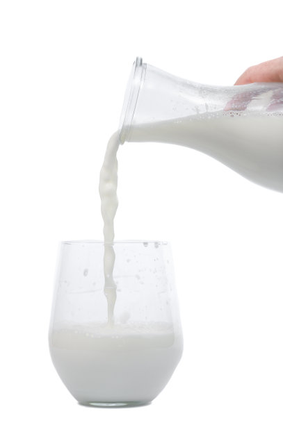 开菲尔酒从瓶子里倒进白色背景的玻璃杯里图片下载