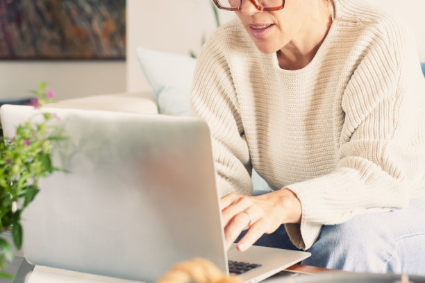 满意的成年女性在舒适的沙发上放松，在家里使用笔记本电脑，快乐的女士在社交网络上与朋友聊天，度过慵懒的周末，看电影，网上购物，写电子邮件图片下载