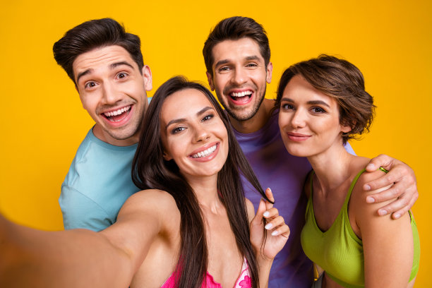 四个人聚在一起的自拍照片，在生动的色彩背景下休息放松图片下载