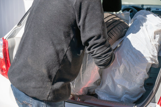 把轮胎放进汽车后备箱的人图片下载