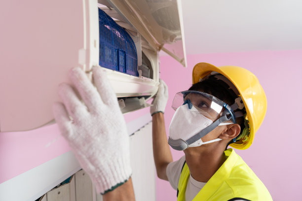 一名亚洲男性工人为家中安装的空调提供清洁服务。图片下载