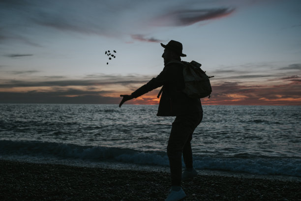 日落时分，男游客在海滩上的照片图片下载