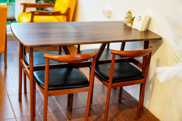 一张木制餐桌的图片，有一个美丽，简单的设计，可供4人使用。图片下载