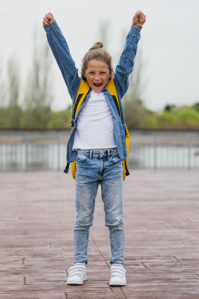 上学的小男孩举起双手，背着背包。图片下载