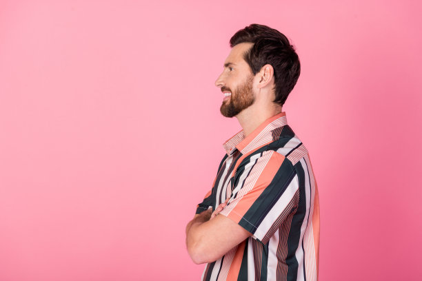 侧面资料照片微笑的黑发男性销售经理双手交叉自信的姿势理发店孤立的粉红色背景图片下载