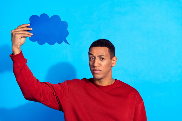 沉思的人的照片手握空的空间云形气泡卡孤立在蓝色的背景图片下载