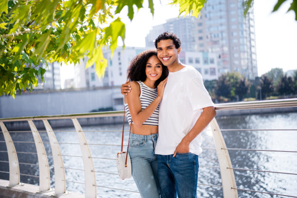 照片正面漂亮甜美闪亮的妻子丈夫拥抱湖边散步周末旅行散步阳光明媚的天气外面图片下载