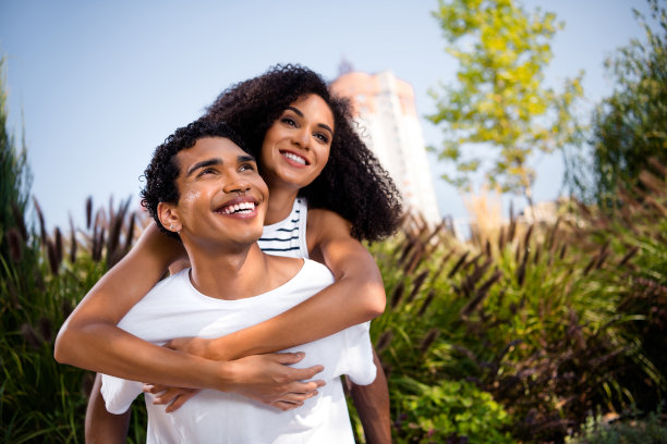 照片迷人闪亮的妻子和丈夫有乐趣享受蜜月纪念日，阳光明媚的天气热带花园户外图片下载