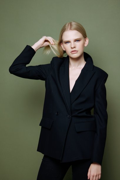 一位不可思议的专业模特系好头发，看着镜头。服装品牌的概念照片。时尚西装的酷报价图片下载