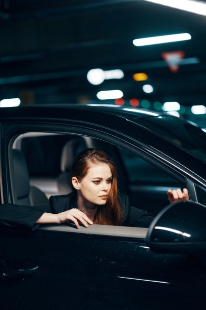 从侧面拍摄的垂直照片，晚上，一个女人坐在车里，看着窗外，欣赏她在侧镜中的倒影图片下载