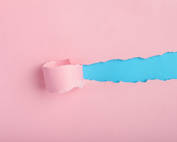 撕破的粉红色纸露出蓝色的背景。背景，纸张质感。图片下载