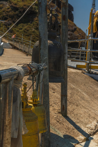 一个黄黑相间的铃铛挂在一根金属杆上图片下载