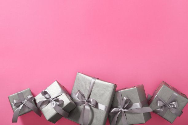 单色灰色礼品盒与银带粉红色的背景。Copyspace图片下载