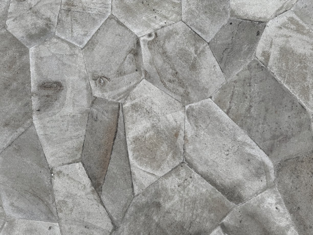 随机切割的鹅卵石石板的特写照片，自然灰色和深灰色的鹅卵石石材无缝纹理作为户外公园地板。图片下载