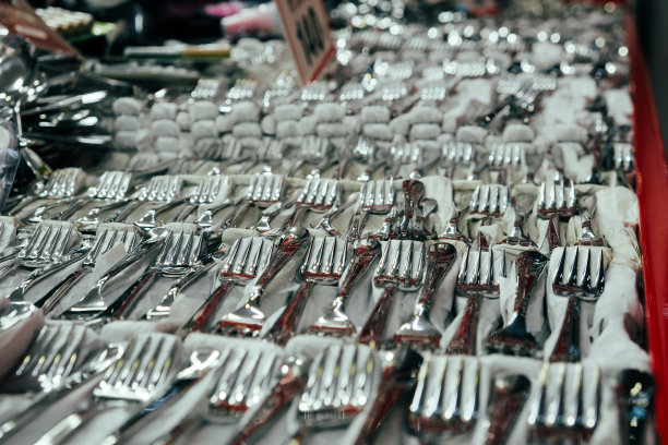 太多的金属叉子坐在柜台上，站在商店里卖金属叉子，概念创意照片图片下载