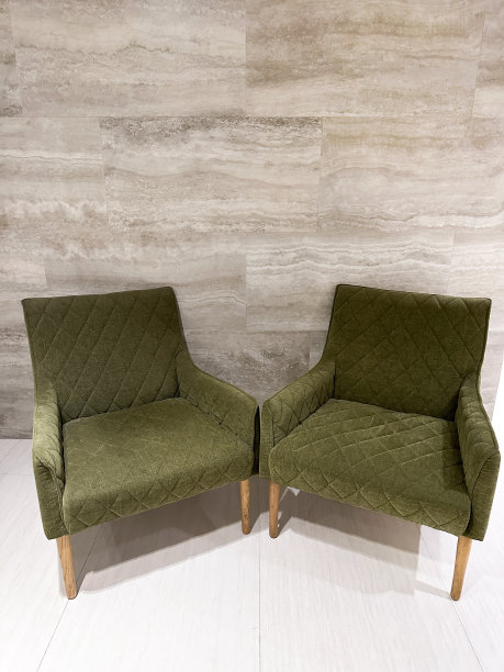 两张特写图片，绿色，绗缝图案的天鹅绒扶手椅在公共大厅，米色，石材效果，瓷墙砖背景，重点在前景图片下载