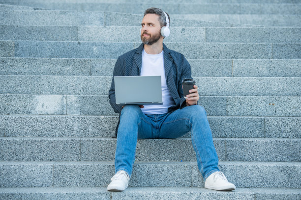 在笔记本电脑上喝咖啡的网上研讨会照片。男子网络研讨会在线户外。图片下载